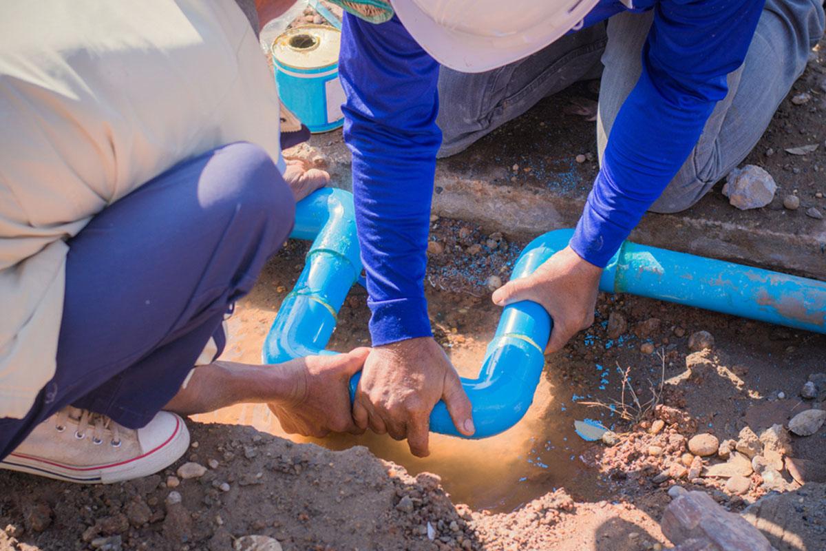 people digging near pipes