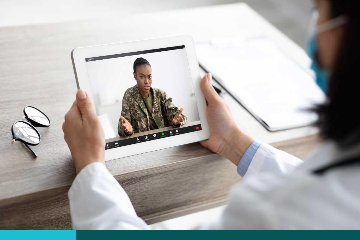 Woman in fatigues doing a telehealth meeting with her doctor