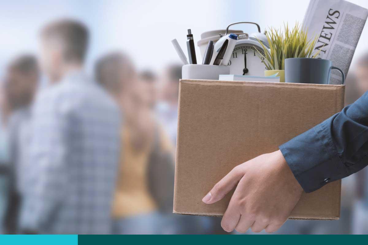 Woman carrying her office belongings out in a box