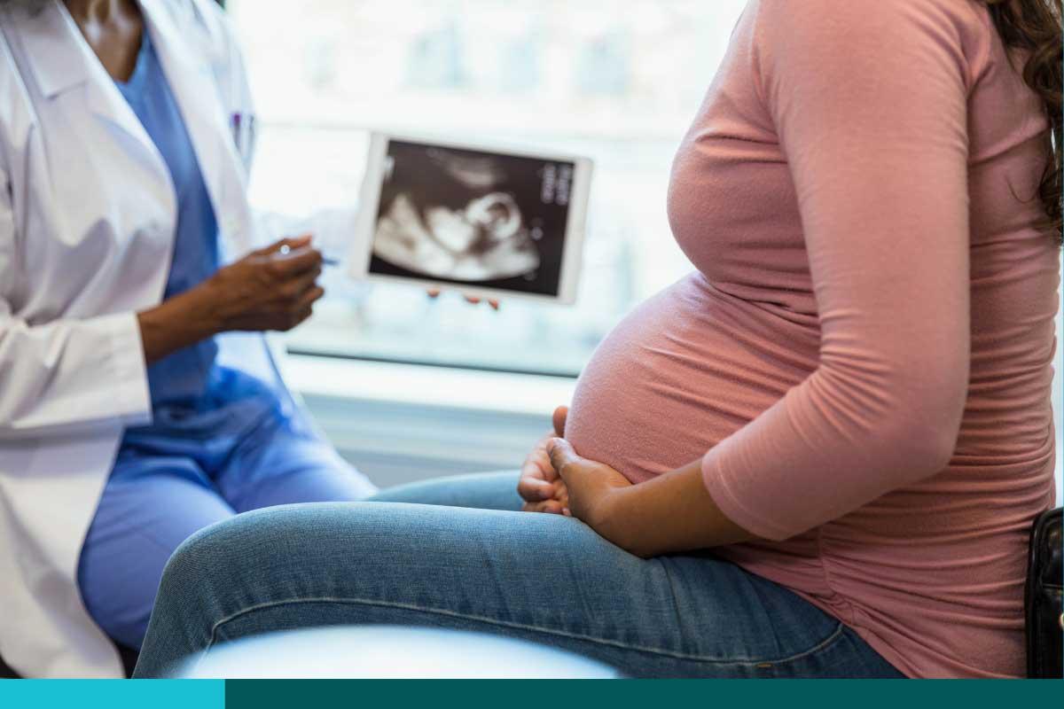 Pregnant woman at doctor's office looking at sonogram